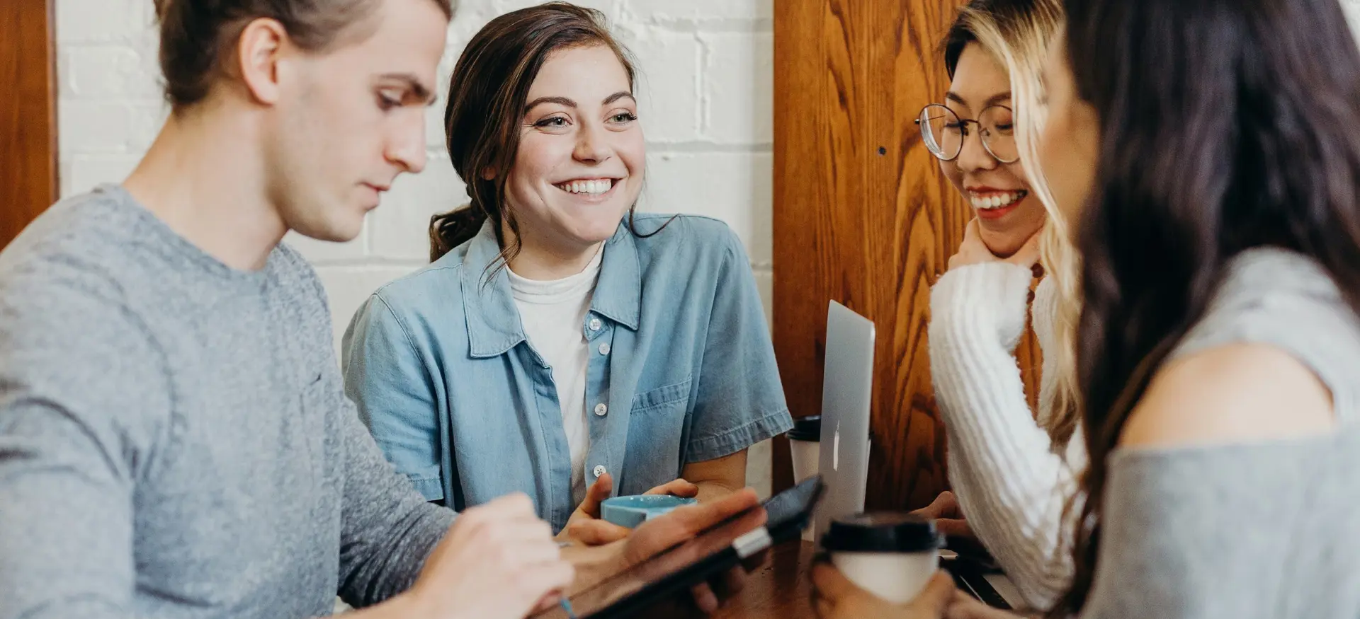 Group of Students Smiling around a tablet