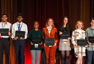 A bunch of people holding awards on stage