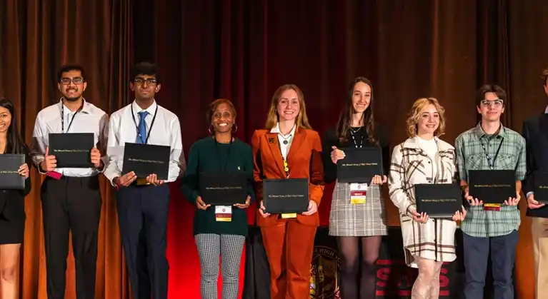 A bunch of people holding awards on stage