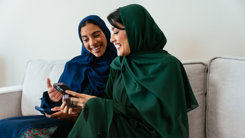 Two women wearing traditional abayas