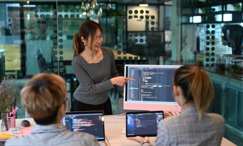 A young woman pointing at the computer screen