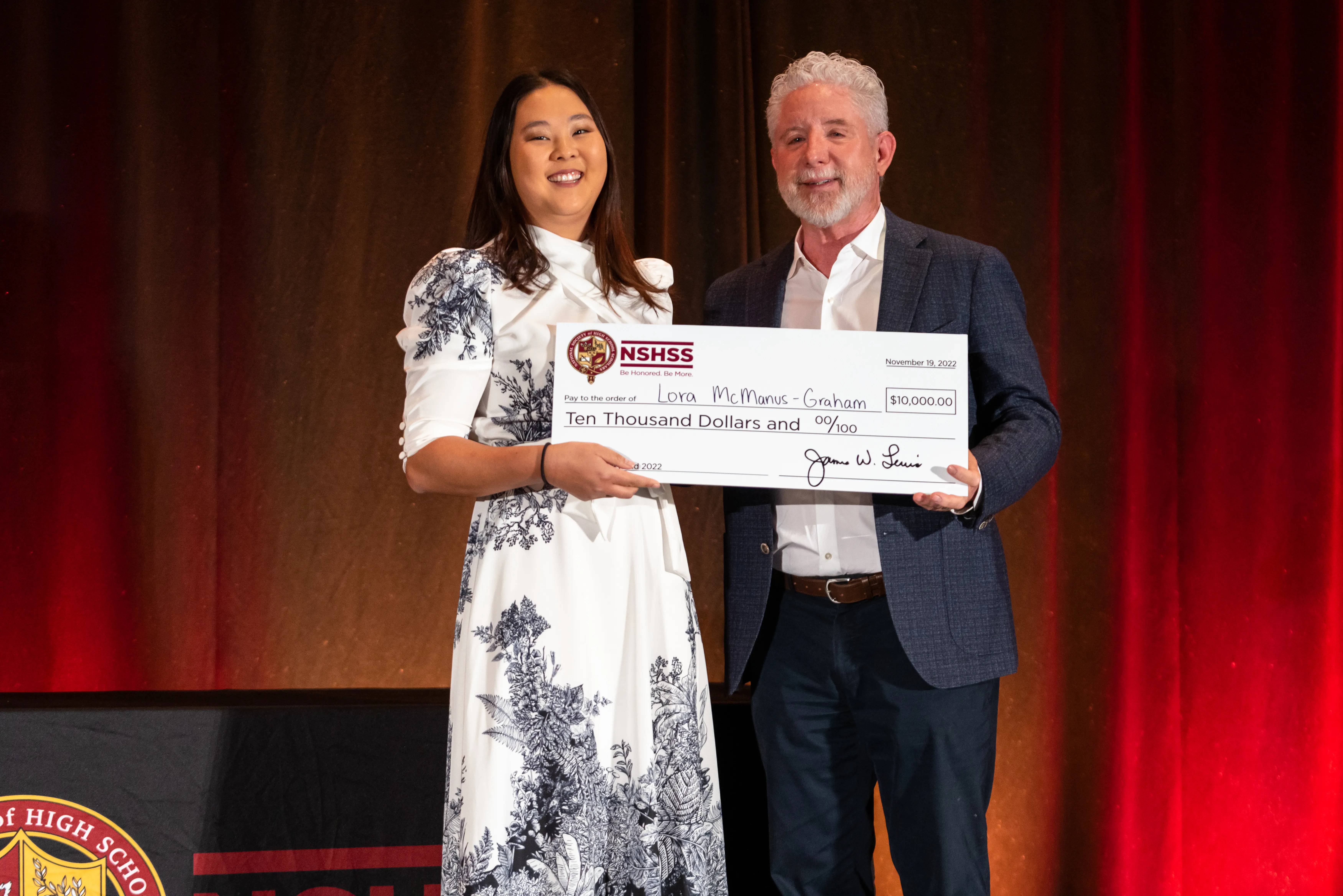 Jim and a woman holding a $10,000 check