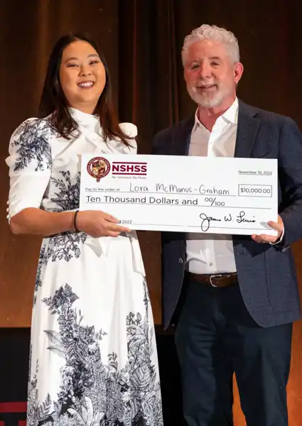 Jim and a woman holding a $10,000 check