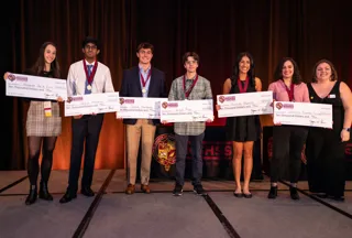 A young group all holding checks