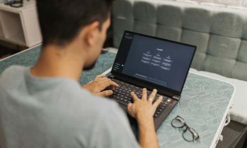 A man typing on is laptop while using ChatGPT