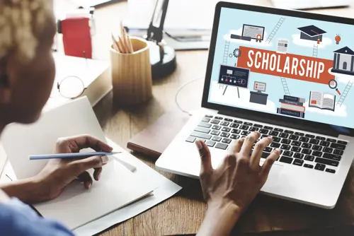 A girl applying for scholarships on her laptop computer
