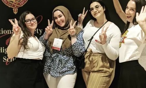 Students posing in front of the photo wall