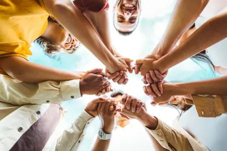 group of people holding hands in togetherness